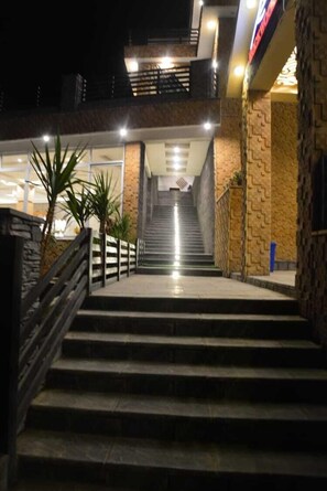 A staircase leading to an upper level with a view of the cityscape. - Rockwood Resort (Gilgit)