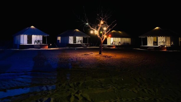 A row of tents with a tree in the center, each tent has a covered seating area. - Barna Desert Camp (Jaisalmer)