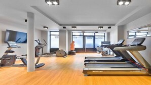Ein modernes Fitnessstudio mit Laufbändern, Ergometer und einem Crosstrainer.