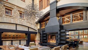A spacious lobby with a stone fireplace, comfortable seating, and a modern chandelier. - Three Bedroom Residential Suite at The Sebastian Vail (Vail)
