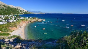 A coastal area with clear waters, boats, and a small settlement with houses and a beach. - Kostrena Apartment Maja (Kostrena)