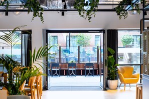 A modern indoor space with large windows, indoor plants, and seating areas. - Staycity Aparthotels, Dublin, City Centre (Dublin)