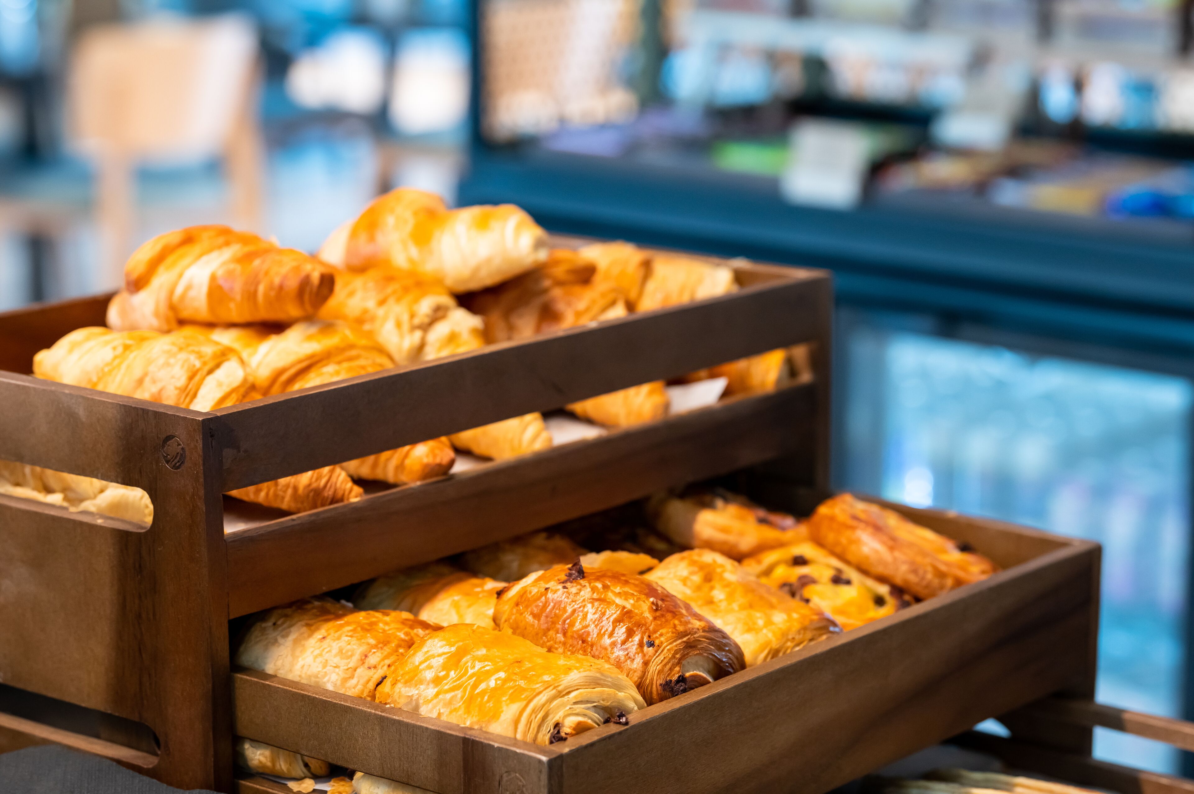 En træskranke med forskellige kager og bagværk, herunder croissanter.