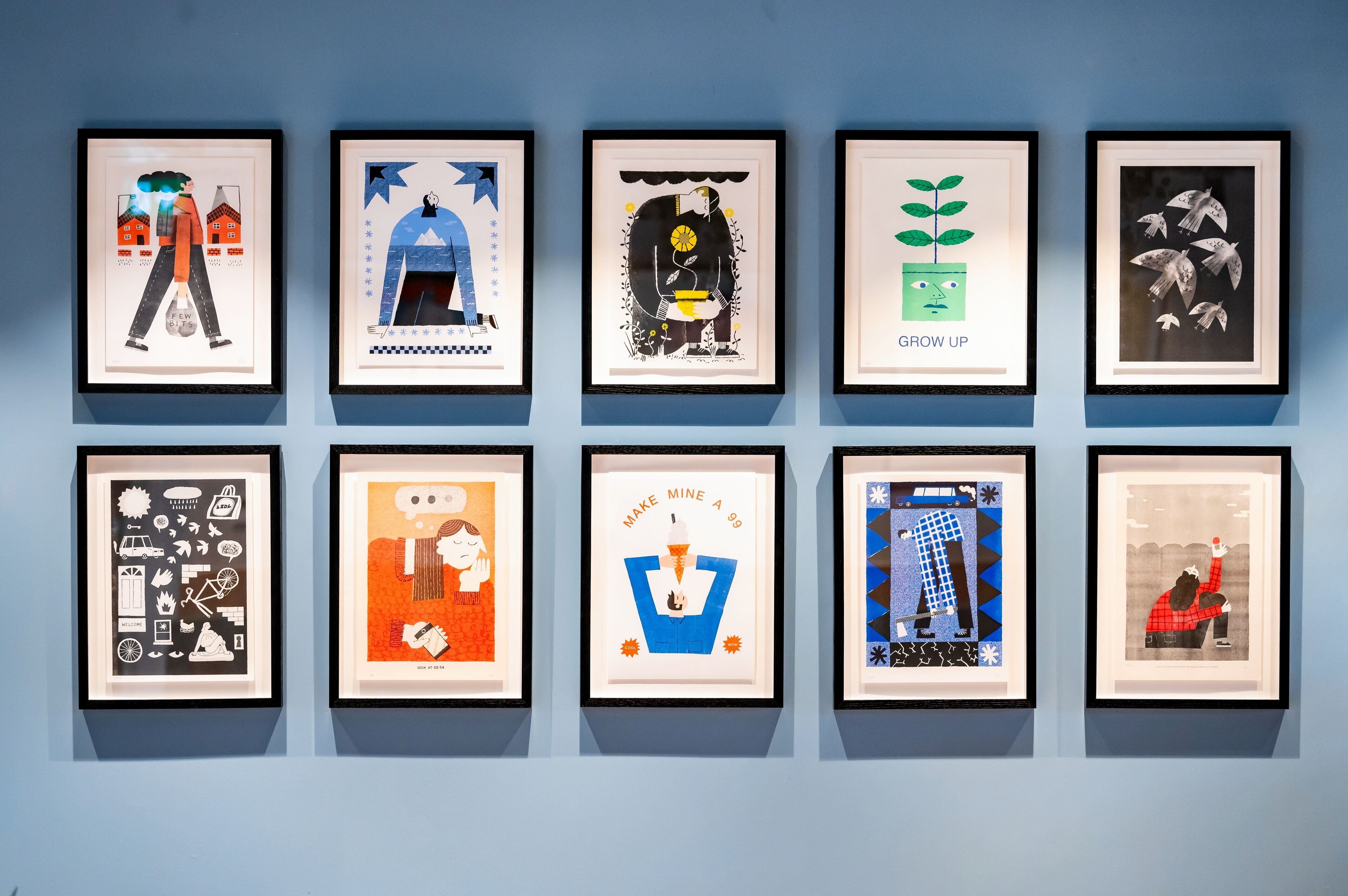 Une série d’œuvres d’art encadrées, accrochées au mur.