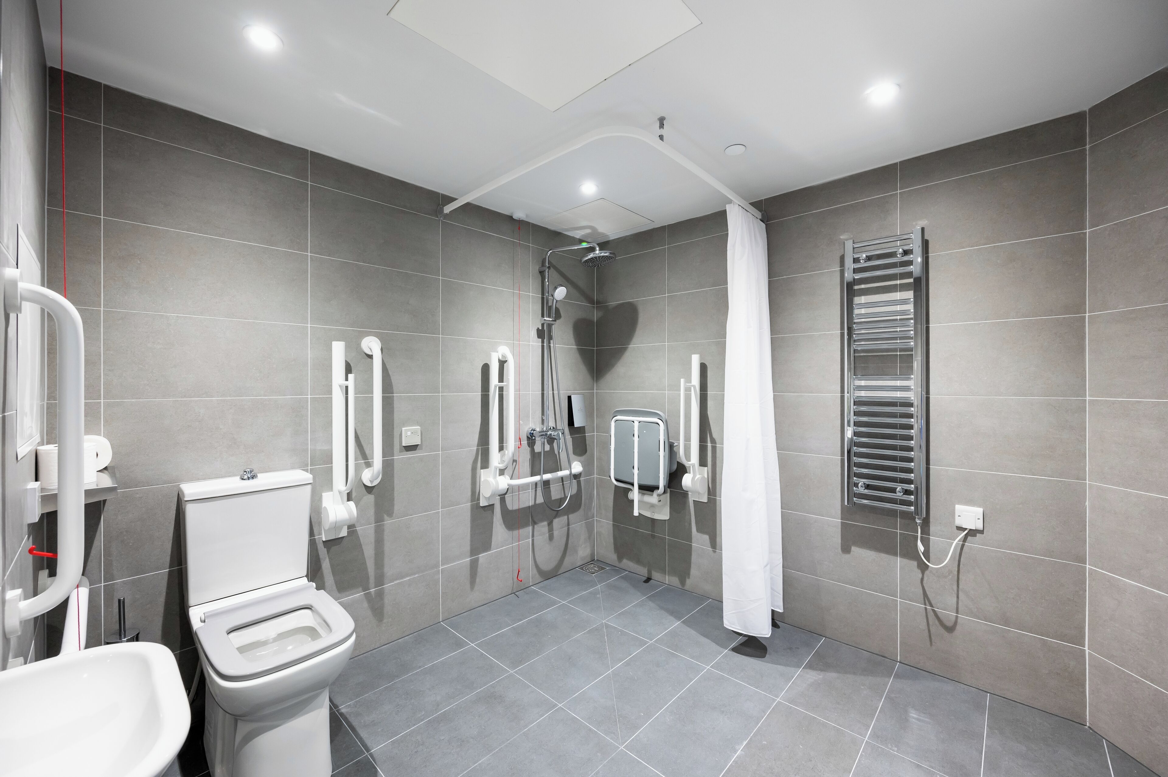 A modern bathroom with a toilet, bidet, and shower.