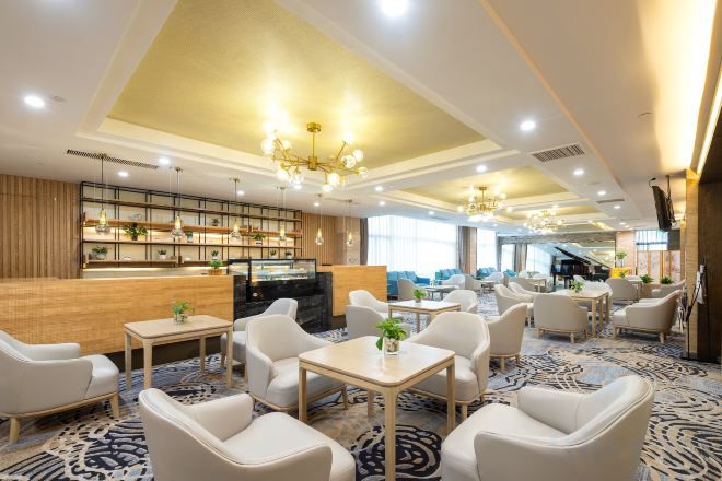 Un vestíbulo de hotel con una recepción, zona de estar y un bar.