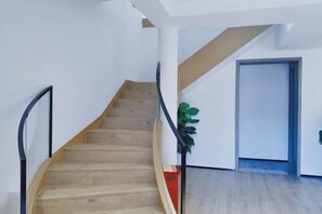A staircase with wooden steps and black handrails, leading to a door. - Yinfeng Holiday Resort (Ningbo)