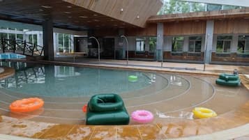 Una piscina interior con techo de madera y vistas al exterior.