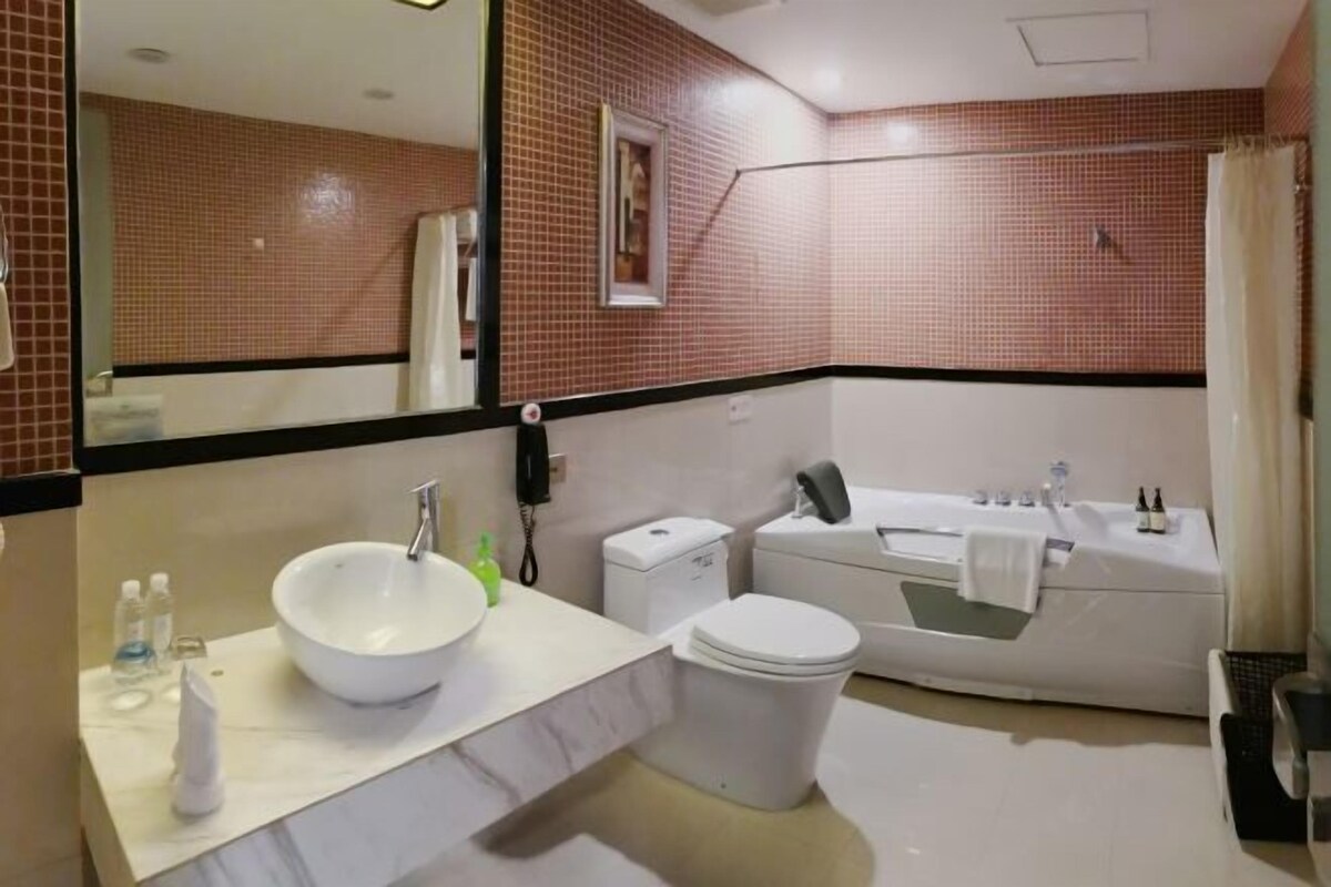 A modern bathroom with a white sink, toilet, and bathtub.