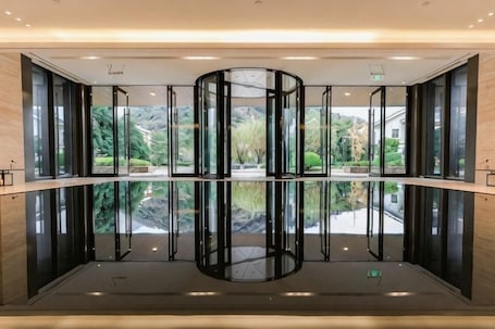 A revolving door with glass panels and a reflection of the surrounding area.. Yinfeng Holiday Resort