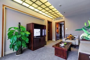 A living room with a TV, a coffee table, and two sofas. - Yinfeng Holiday Resort (Ningbo)