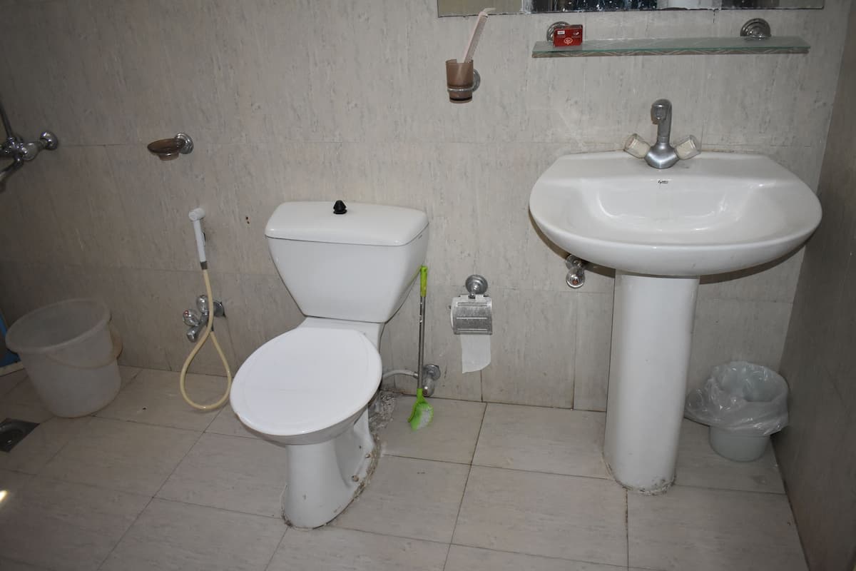 A bathroom with a toilet, sink, and shower.