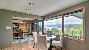 Ein Essbereich mit Blick auf Berge und einen See, Holzboden und modernes Interior Design.
