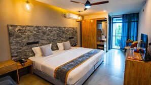 A modern hotel room with a large bed, a desk, a wardrobe, and a view of the outdoors. - Maa Thundi (Fuvahmulah)
