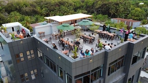 A rooftop terrace with outdoor seating and a view of surrounding greenery. - Maa Thundi (Fuvahmulah)