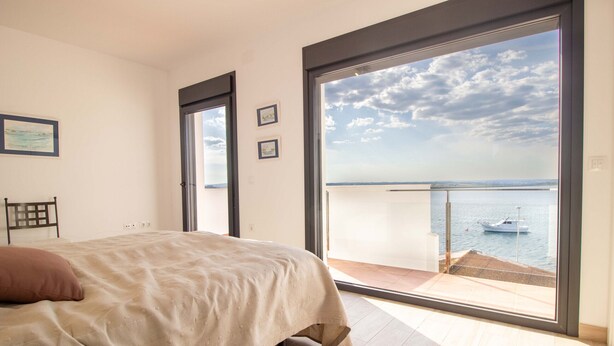 A bedroom with a large window offering a view of the sea and a boat. - Apartment 4 bedrooms Center of Ayamonte with stunning Views DEK01 (Ayamonte)