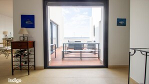 A room with a table and chairs, a wine rack, and a view through a glass door. - Apartment 4 bedrooms Center of Ayamonte with stunning Views DEK01 (Ayamonte)