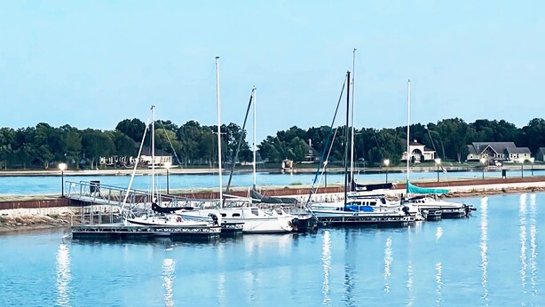 A marina with several boats docked, a dock, and a building in the background. - Lakefront Paradise with Stunning Views! (Corsicana)