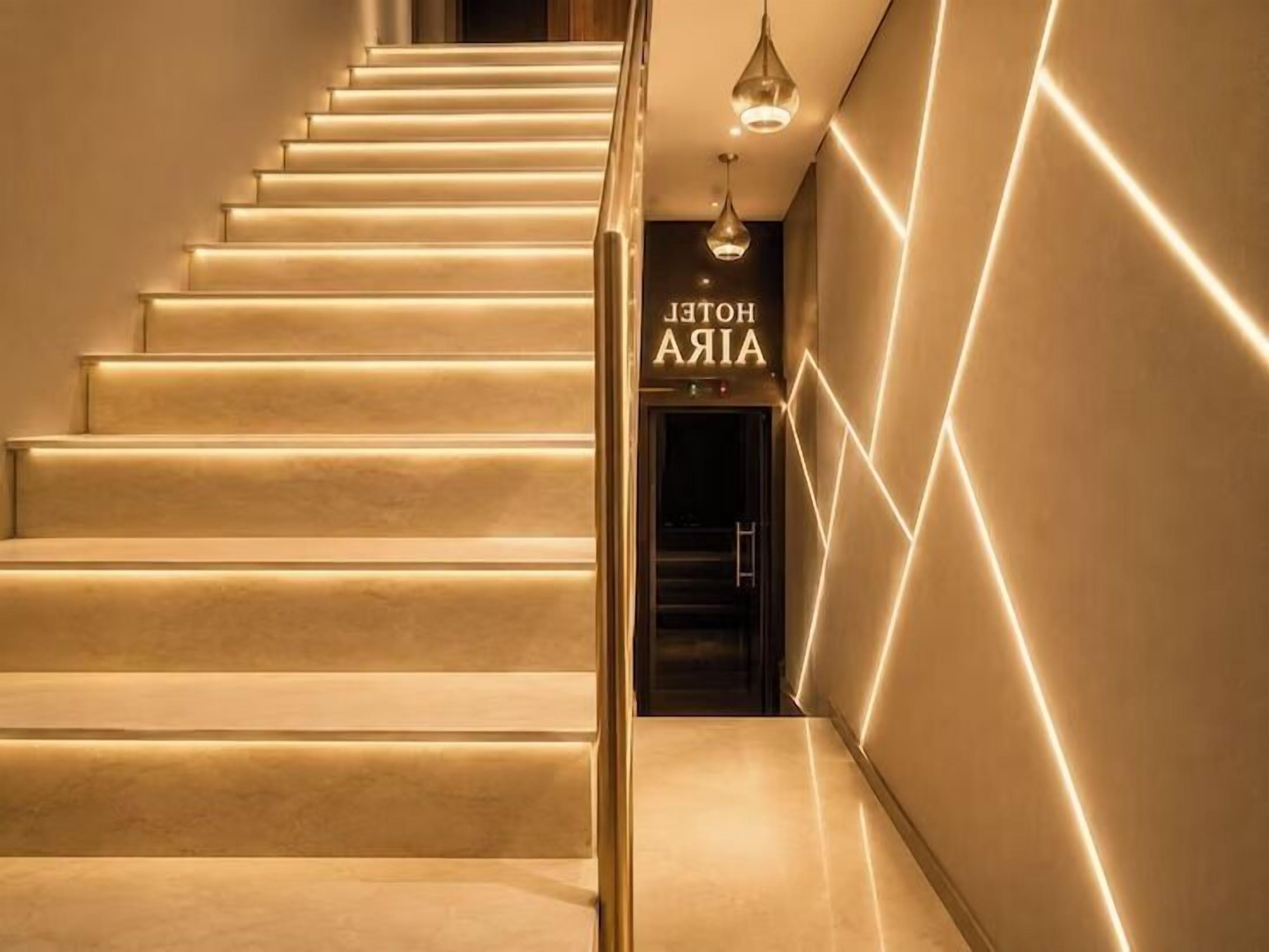 Uma escadaria com uma placa indicando 'HOTEL AIA' que leva a um interior escuro.