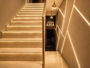 A staircase with a sign reading 'HOTEL AIA' leading to a dark interior. - Staybook Hotel Aira  (New Delhi)