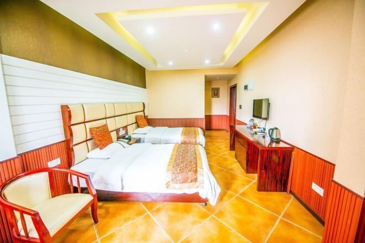 Quarto de hotel com uma cama grande, uma escrivaninha e uma cadeira.