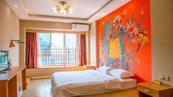 A hotel room with a bed, a desk, and a large window.