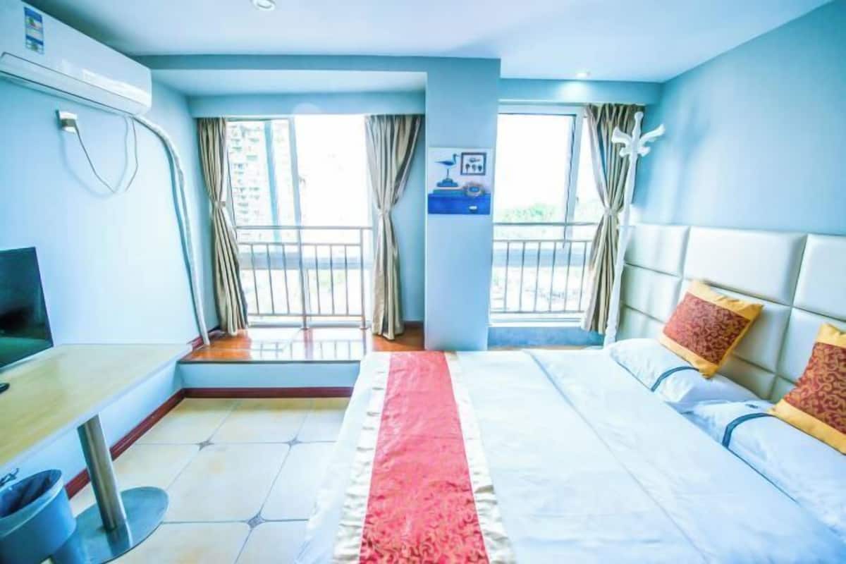 Une chambre d’hôtel avec un lit, un bureau, une télévision et une fenêtre avec des rideaux.