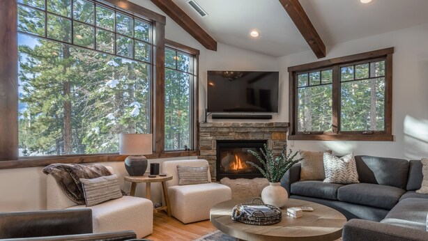 A cozy living room with a fireplace, large windows, and a comfortable seating area. - One-of-a-Kind Luxury Golf Course Home, 2 Private Hot Tubs, Gas Grill & More (Mammoth Lakes)