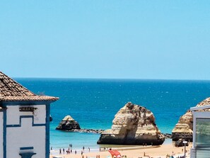Vista costera con playa, formaciones rocosas y cielo despejado.