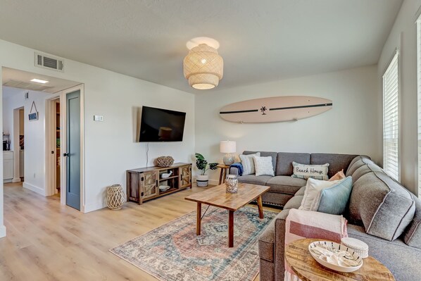 Ein Wohnzimmer mit einer Couch, einem Couchtisch und einer Surfbrett-Dekoration.