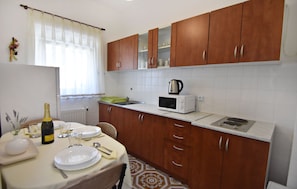 Enjoy a meal or gathering in this kitchen with a microwave, countertop, and table.