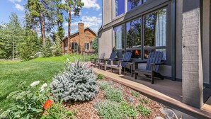 Una casa moderna con un patio amueblado y un jardín con diversas plantas.
