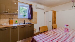 A compact kitchen with a window, a sink, and a table with a checkered tablecloth. - S2 - Modern Studio, Just 50m From the Beach (Korcula)