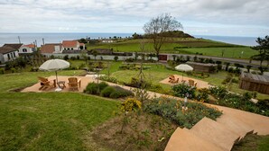 A residential area with a grassy lawn, outdoor seating, and a view of the sea. - Tradicampo-Cycas-Estúdio da Varanda, panoramic view - NEW LISTING (Algarvia)