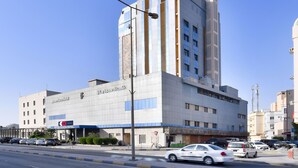 A modern hotel with a prominent vertical design, multiple floors, and a clear blue sky in the background. - OYO 125 Moon Plaza Hotel (Manama)