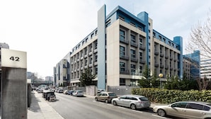 A multi-story building with a modern architectural design, featuring a prominent blue and beige color scheme.