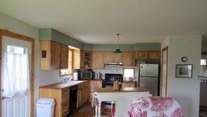 A compact kitchen with wooden cabinets, a microwave, stove, and refrigerator.