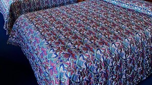 A hotel room with two beds, each with patterned bedding, a bedside table with a lamp, and framed pictures on the walls. - Home Place Inn (Nicholasville)