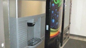A vending machine with a colorful design, a coin slot, and a beverage dispensing area. - Home Place Inn (Nicholasville)