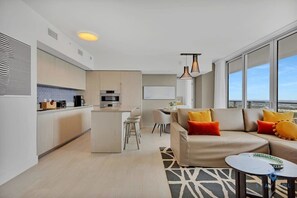 A modern apartment with a kitchen, dining area, and living room.