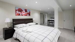 Un dormitorio con una cama grande, una mesita de noche, un escritorio y una silla.