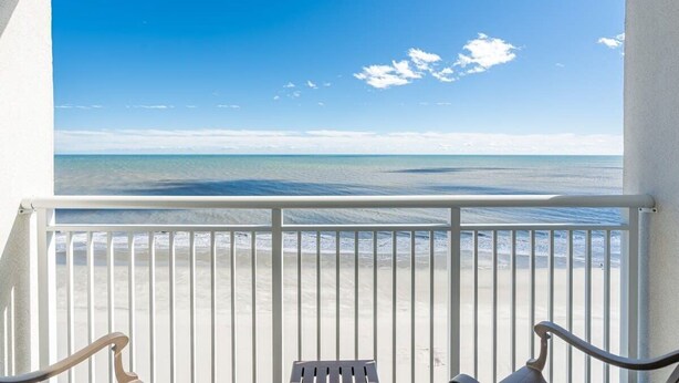 Un balcon avec vue sur la plage et l’océan.