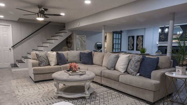 A spacious living room with a sectional sofa, a round coffee table, and a staircase leading to an upper level. - Roanoke’s modern Lower Level Apt. (Basement). (Roanoke)