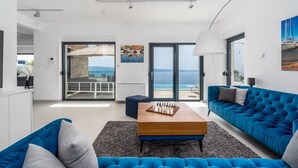 Una sala de estar moderna con un sofá azul, una mesa de centro de madera y un tablero de ajedrez.