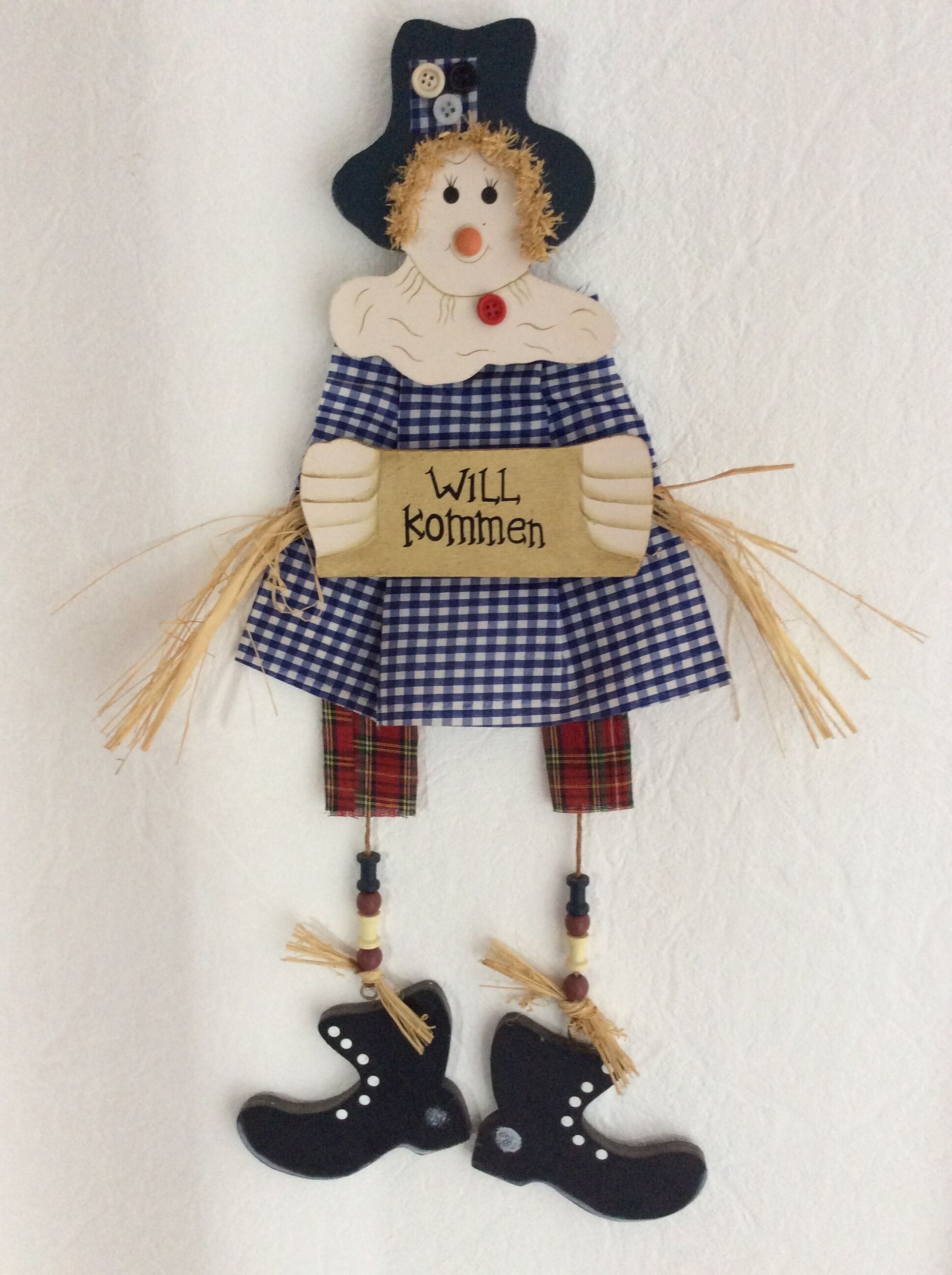 Una figura decorativa con un cartello che riporta la scritta 'WILL kommen'.