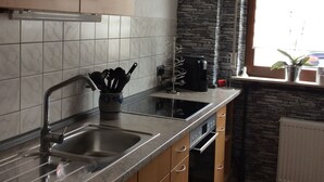 A kitchen with wooden cabinets, a granite countertop, a built-in oven, and a window with a view.