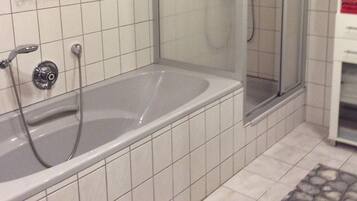 Un bagno con vasca e cabina doccia in vetro.