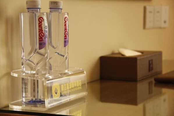 Minibar de hotel con dos botellas de agua Ganten y una caja de pañuelos.