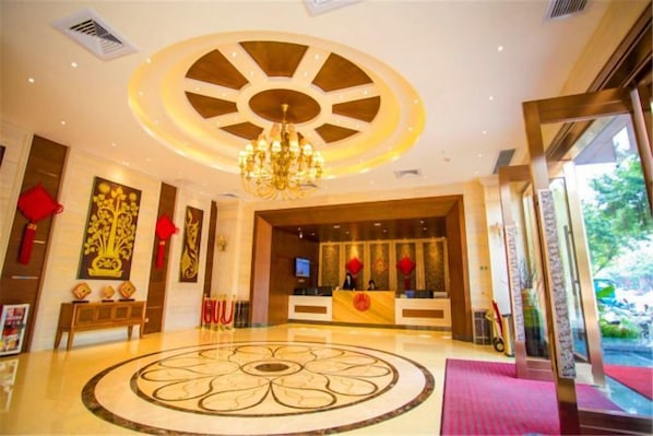 A hotel lobby with a circular floor design, a reception desk, and a chandelier. - Haoda Jiayuan Hotel (Guangzhou)