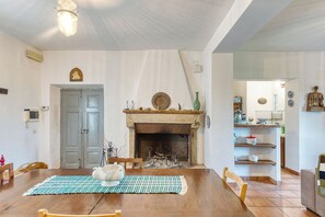 Una sala de estar con chimenea, muebles de madera y un comedor.